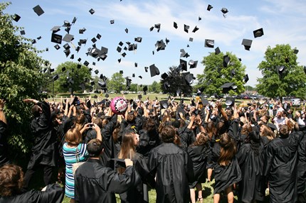 Large group of PHS students tossing their graduation caps in the air