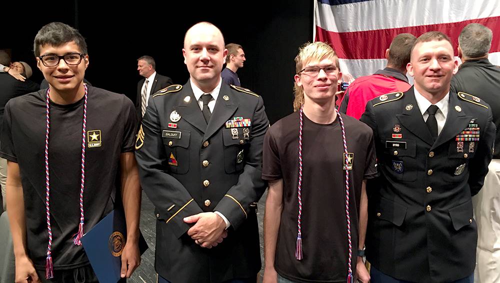 two students and two military representatives at signing day