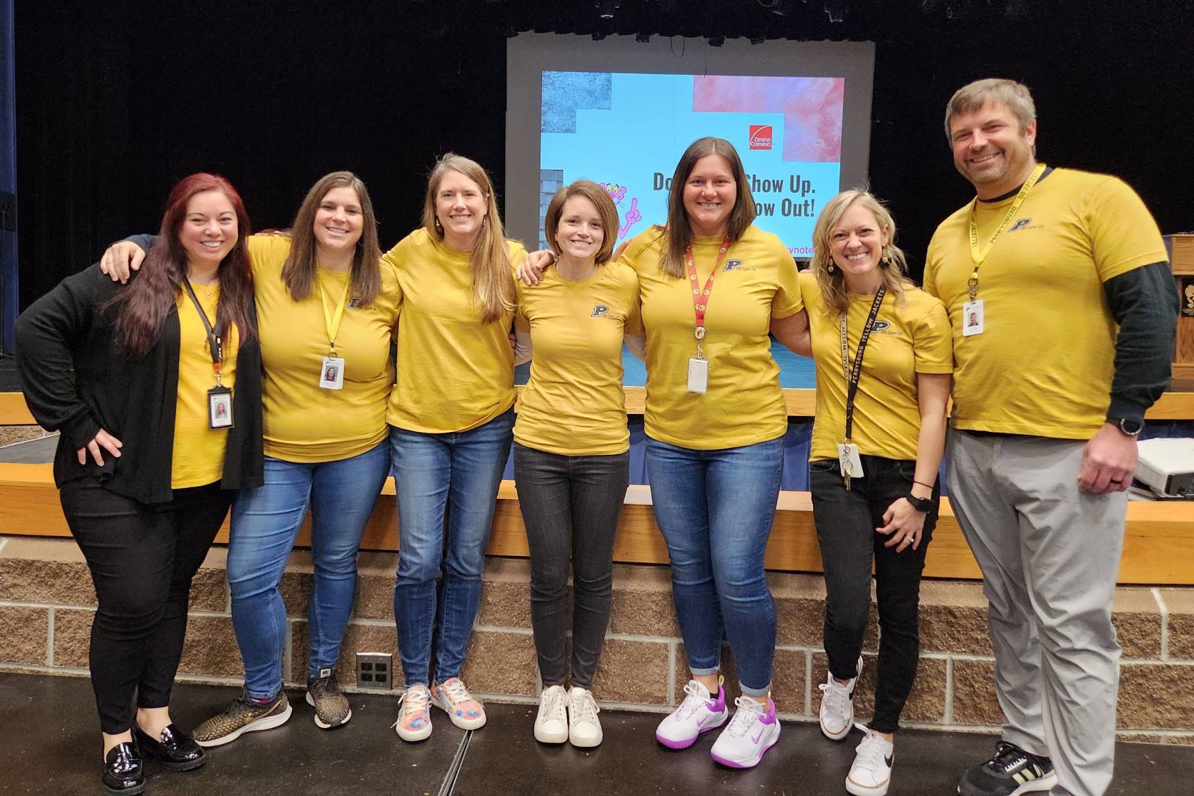 Seven people in matching shirts smiling