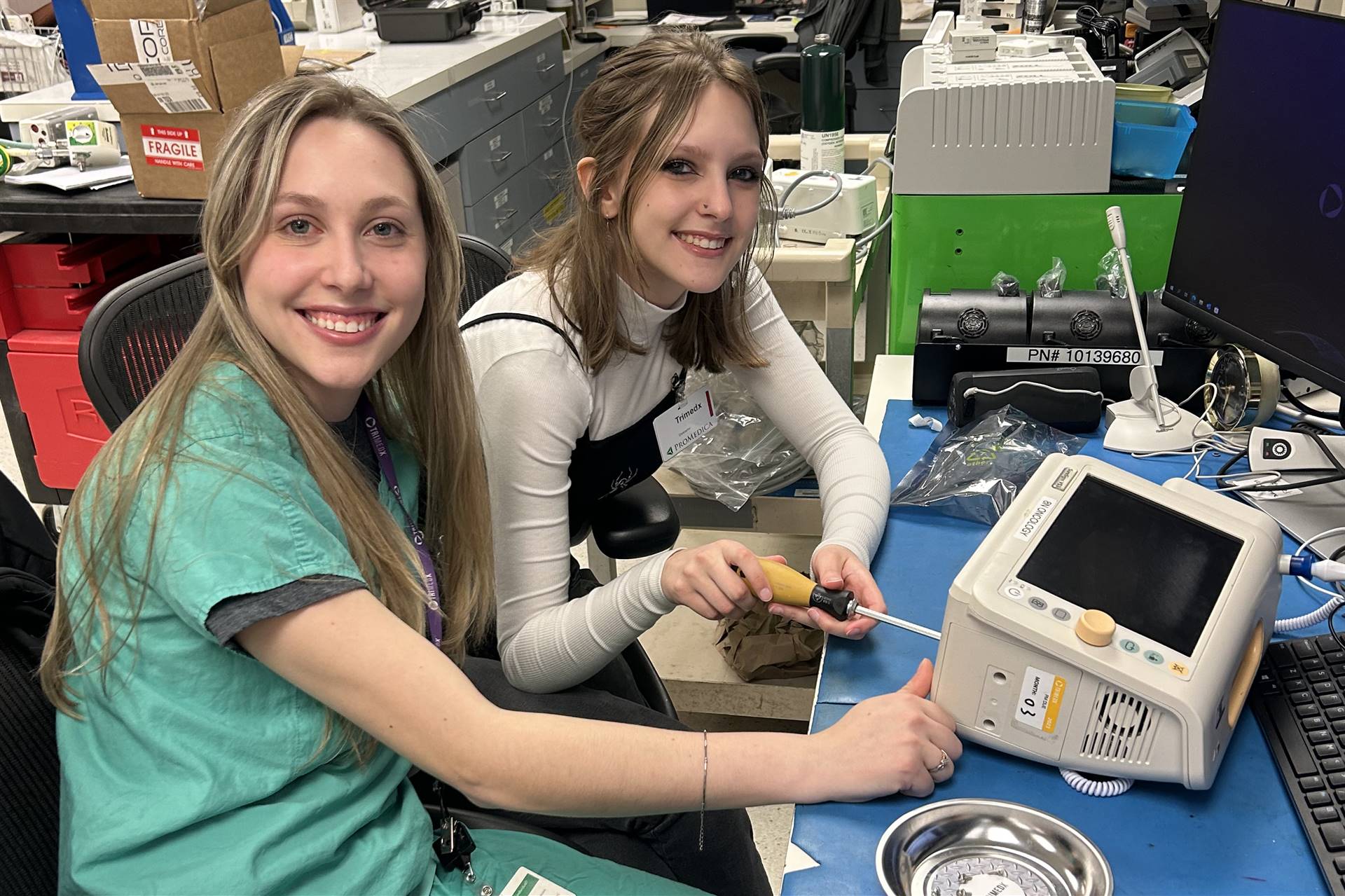 Two people working with tools at a workbench