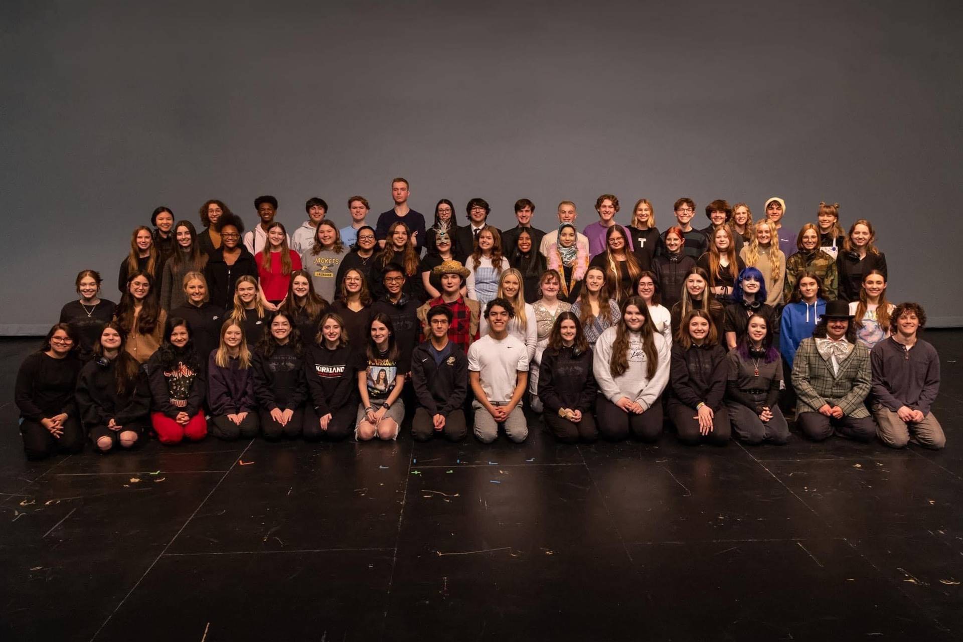 large group of students on stage posing for photo