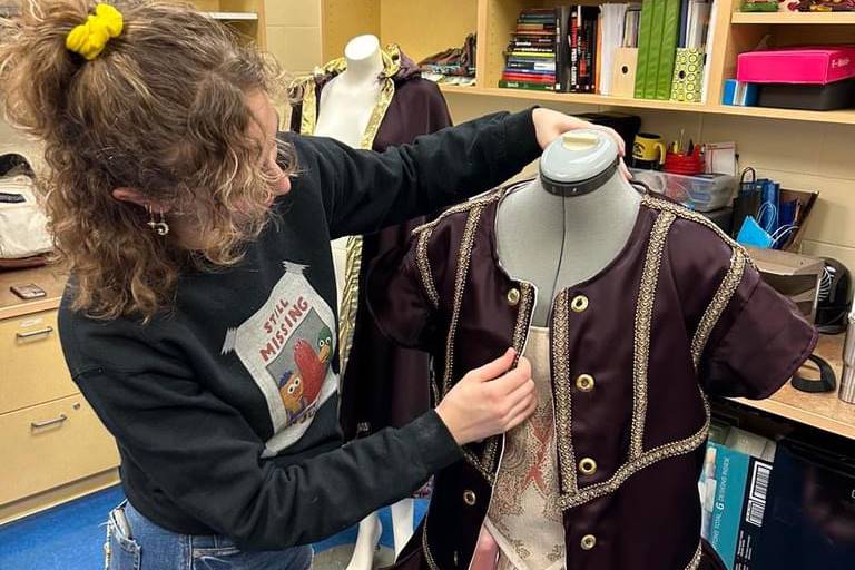 student sewing a costume