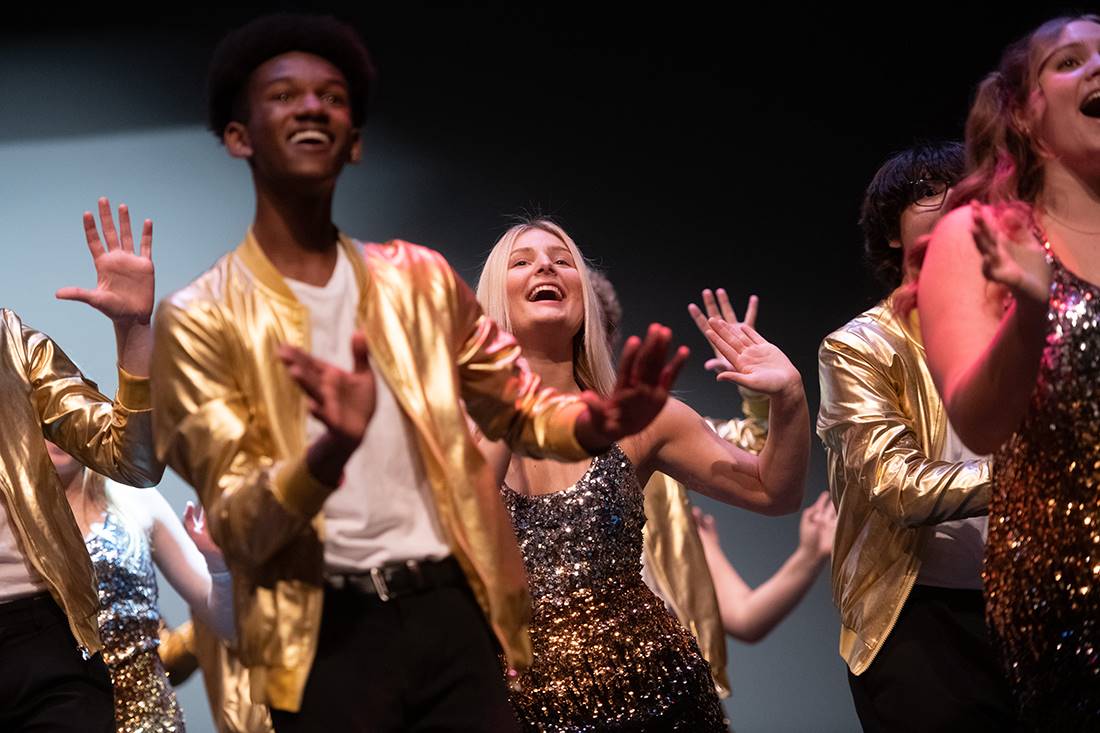 students singing on stage in performance