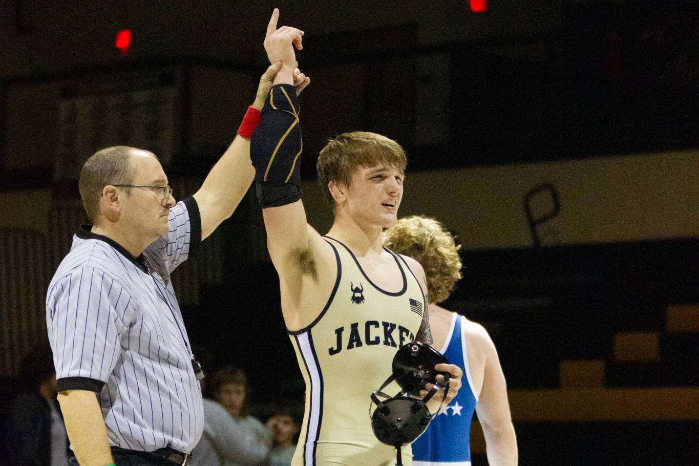 referee and wrestlers in victory pose