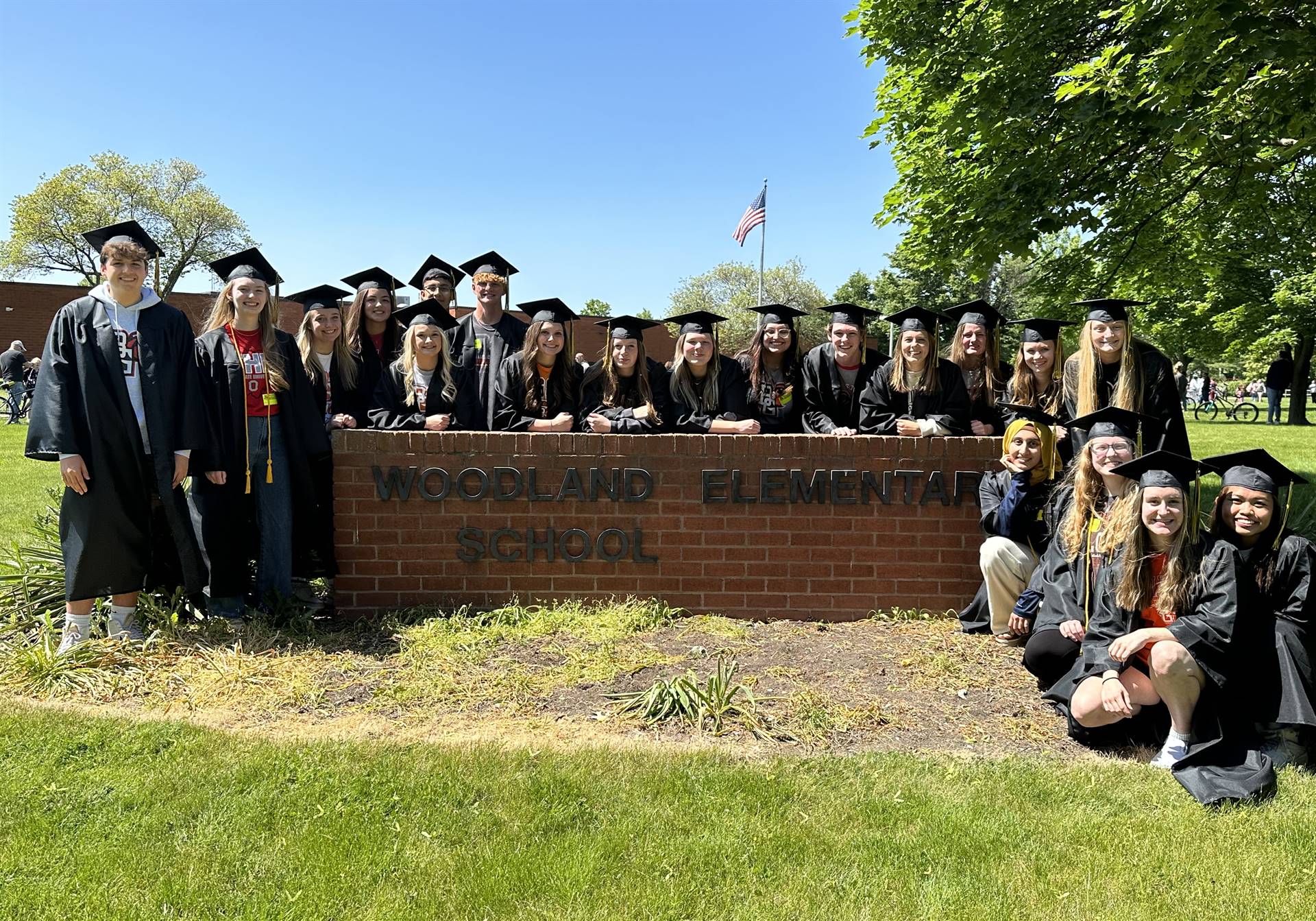 graduates by Woodland sign